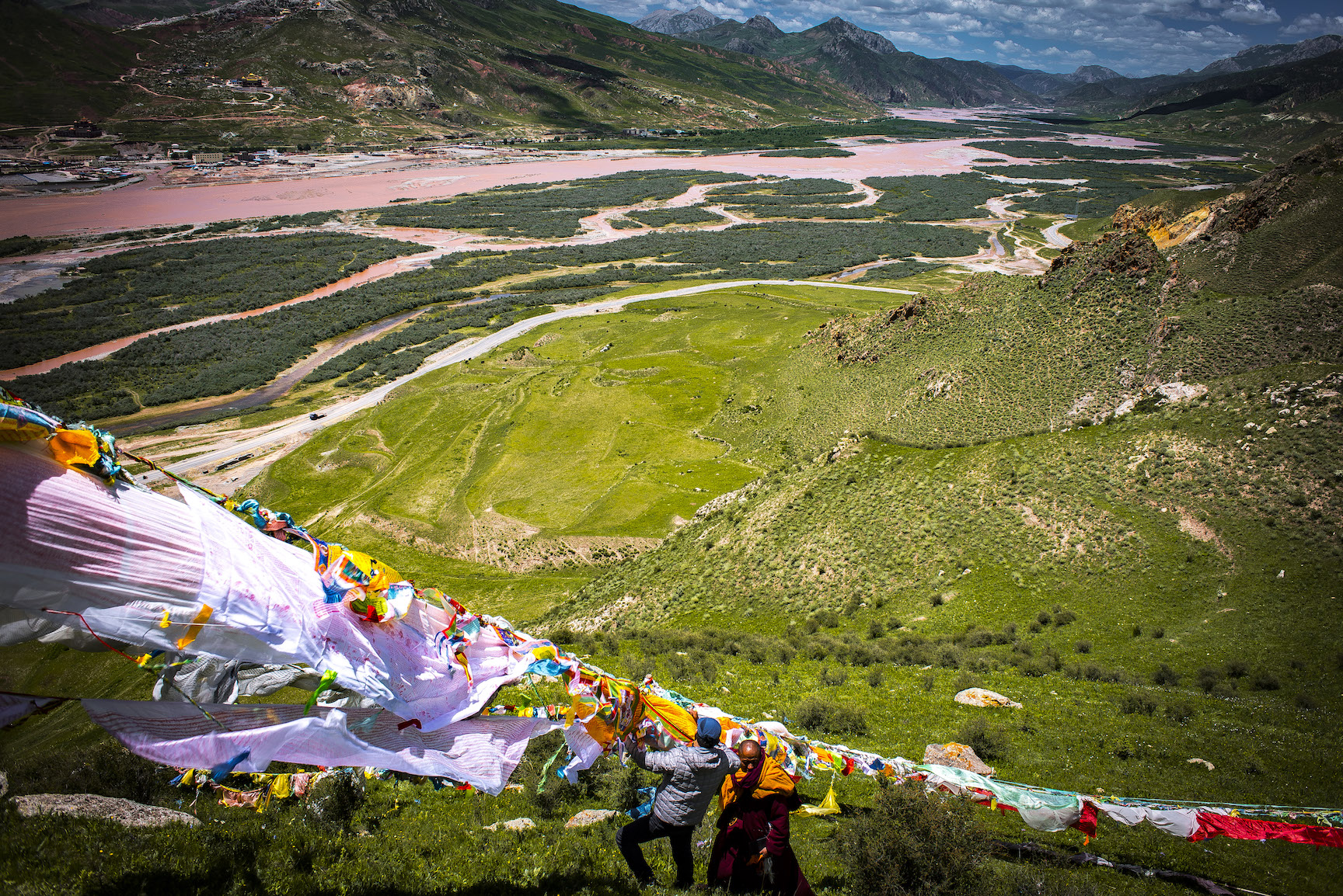 Hanging prayer flags after a ceremony above the Mekong River
