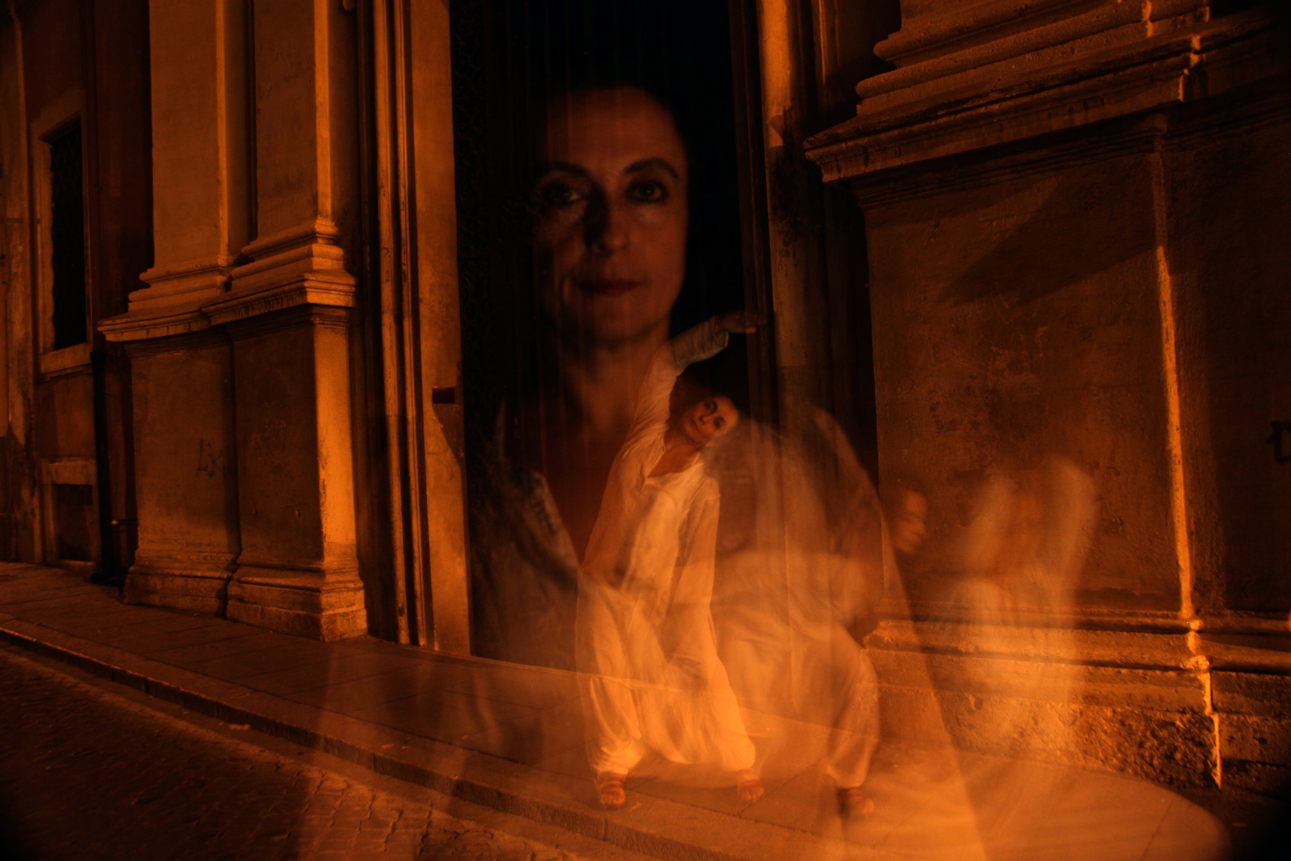 Transparent ghost-like woman standing on quiet street at night