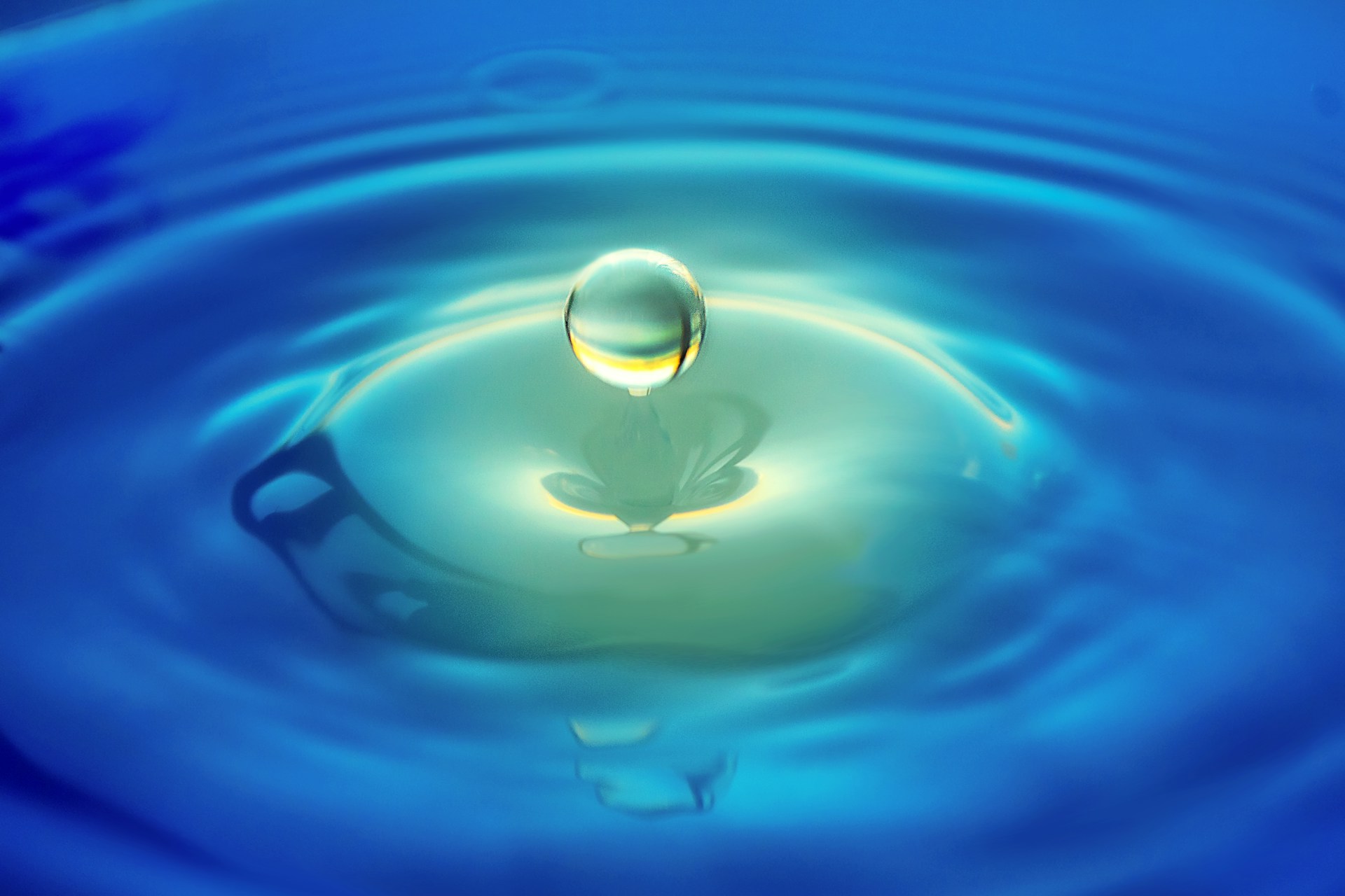 Water droplet splash with blue ripple reflection macro photography